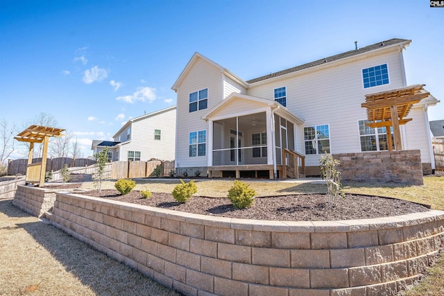 back of property featuring fence and a sunroom