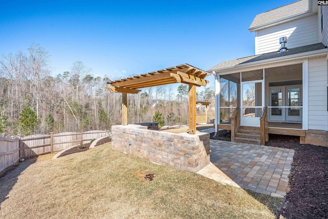 view of yard featuring a patio area, a fenced backyard, and a sunroom