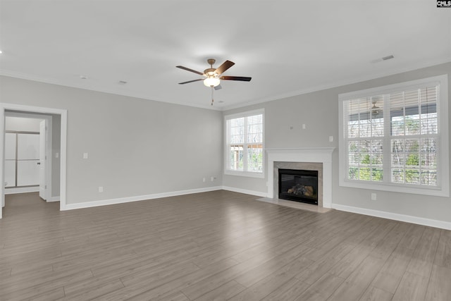 unfurnished living room with visible vents, wood finished floors, and ornamental molding