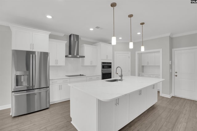 kitchen with white cabinets, appliances with stainless steel finishes, wall chimney exhaust hood, and a sink