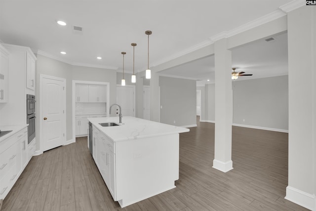 kitchen with visible vents, a sink, wood finished floors, double oven, and ceiling fan