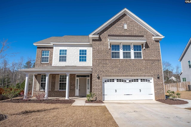 traditional-style home featuring a porch, fence, concrete driveway, an attached garage, and brick siding