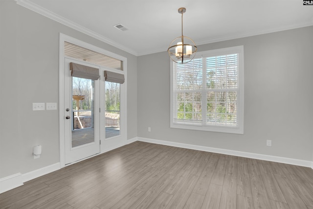 unfurnished dining area with wood finished floors, a healthy amount of sunlight, and ornamental molding