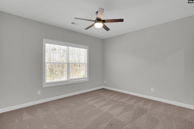 spare room with visible vents, ceiling fan, baseboards, and carpet