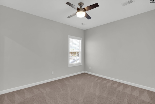 carpeted empty room featuring visible vents, ceiling fan, and baseboards