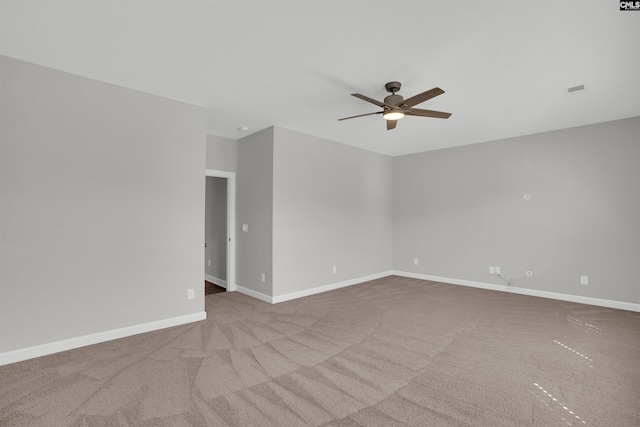 spare room with carpet, baseboards, and ceiling fan