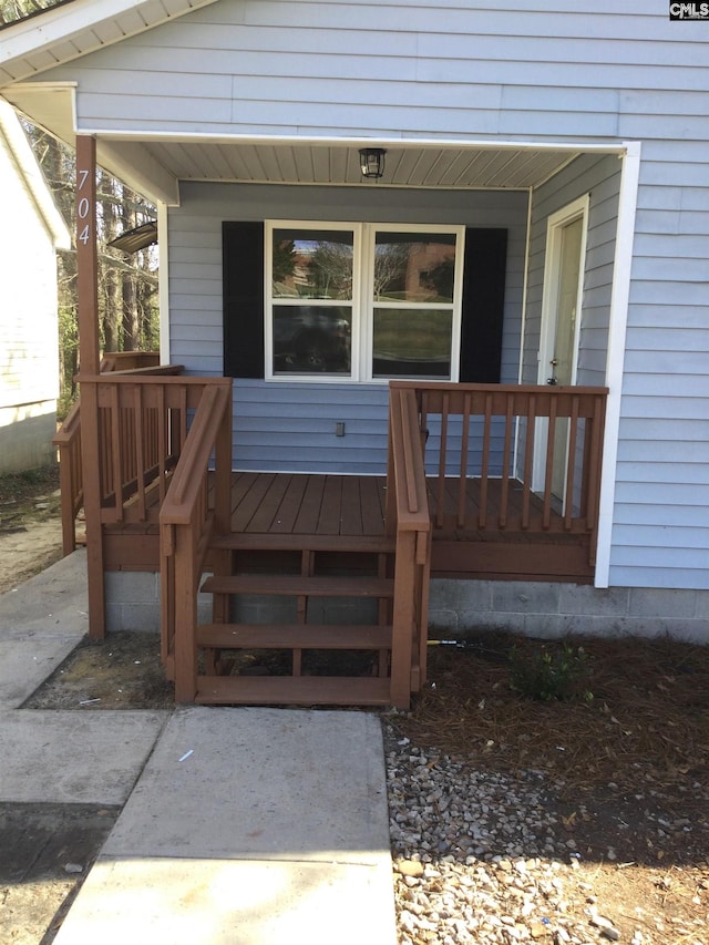 view of exterior entry featuring covered porch