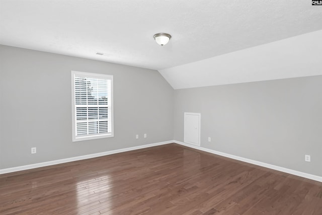 257 Castlebury Dr, Columbia, SC 29229 - bonus room with visible vents, a textured ceiling, baseboards, dark wood-style flooring, and vaulted ceiling