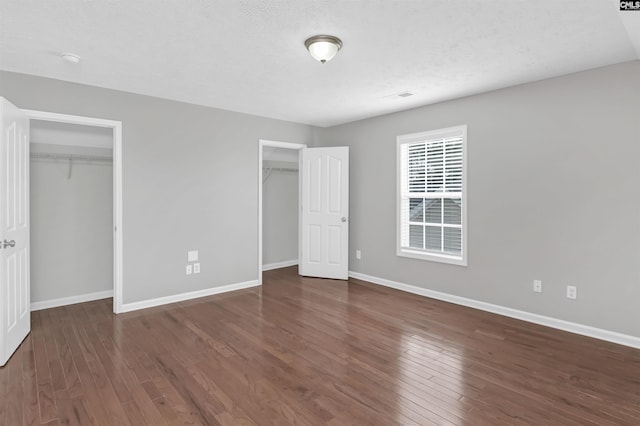 257 Castlebury Dr, Columbia, SC 29229 - unfurnished bedroom with a textured ceiling, baseboards, multiple closets, and hardwood / wood-style flooring