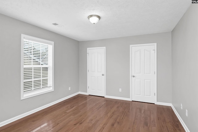 257 Castlebury Dr, Columbia, SC 29229 - unfurnished bedroom with visible vents, a textured ceiling, baseboards, and wood finished floors