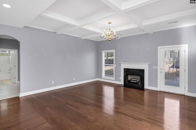 unfurnished living room featuring visible vents, baseboards, a fireplace, wood finished floors, and arched walkways