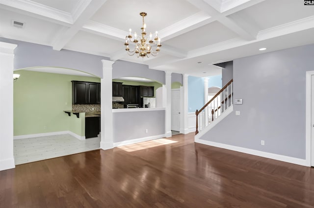 unfurnished living room with visible vents, coffered ceiling, wood finished floors, baseboards, and ornate columns