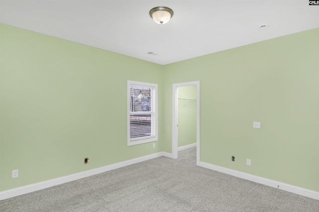 empty room featuring carpet flooring and baseboards