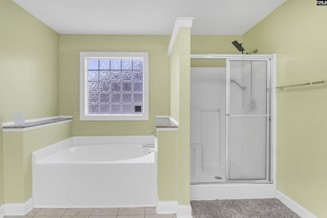 bathroom with tile patterned flooring, a shower stall, a garden tub, and baseboards