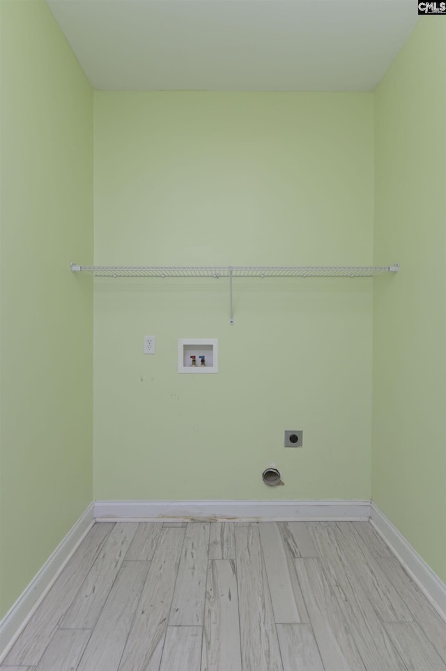 clothes washing area featuring baseboards, laundry area, electric dryer hookup, washer hookup, and light wood-style floors