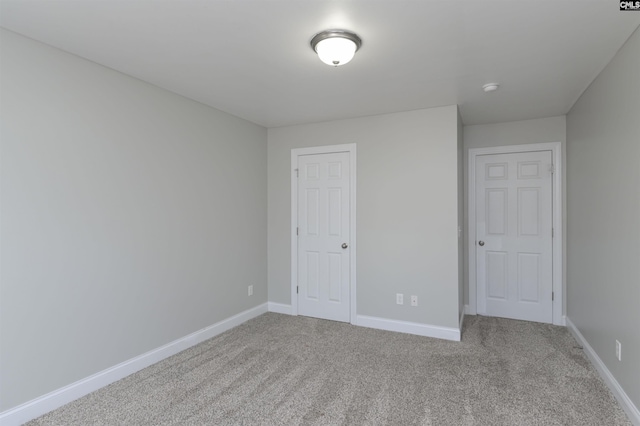 unfurnished bedroom featuring a closet, baseboards, and carpet floors