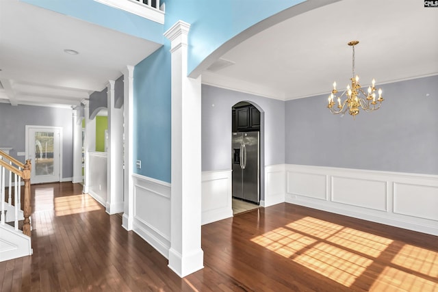 hall with arched walkways, dark wood-style floors, and stairs