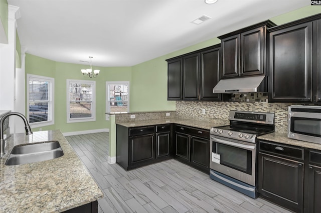 kitchen featuring tasteful backsplash, visible vents, under cabinet range hood, appliances with stainless steel finishes, and a sink