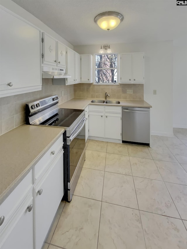 kitchen with under cabinet range hood, a sink, tasteful backsplash, stainless steel appliances, and light countertops