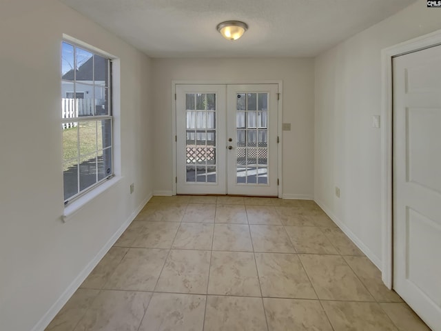 entryway with light tile patterned flooring, french doors, and baseboards