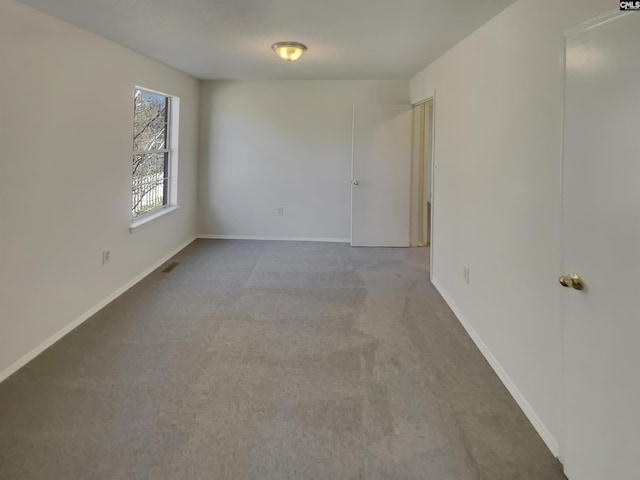 unfurnished room featuring baseboards and carpet