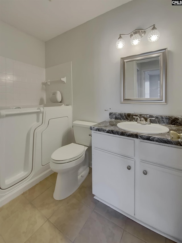 bathroom featuring vanity, toilet, and tile patterned flooring