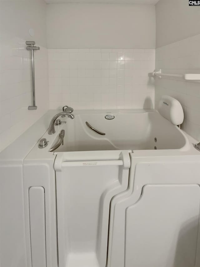 bathroom featuring washer / dryer and a whirlpool tub