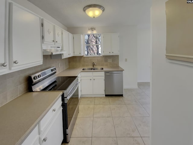 kitchen featuring light tile patterned floors, a sink, stainless steel appliances, under cabinet range hood, and backsplash