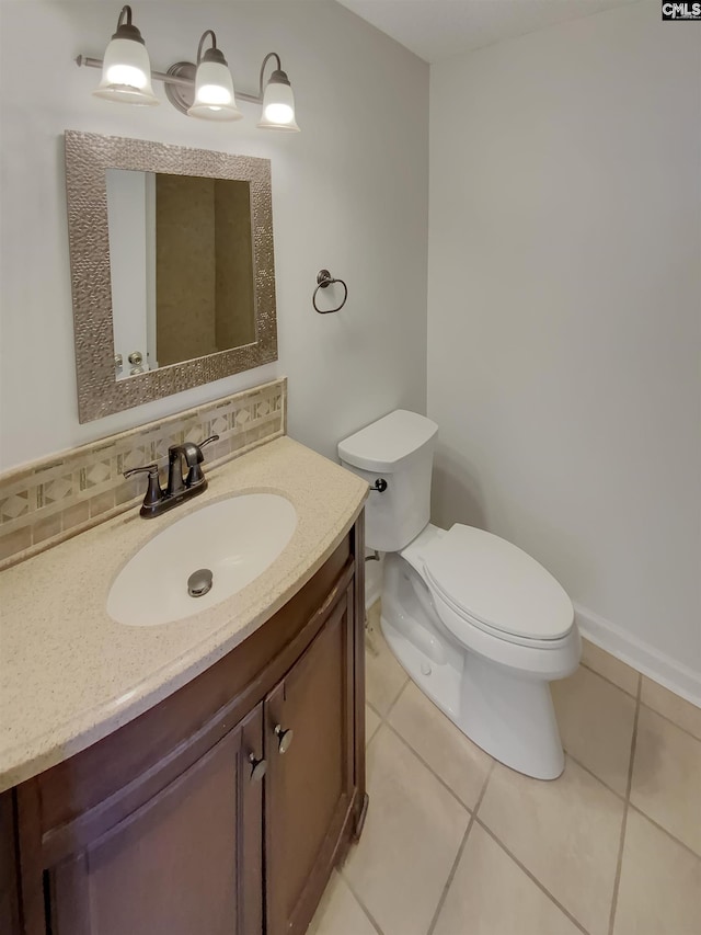 half bathroom featuring tile patterned floors, tasteful backsplash, toilet, and vanity