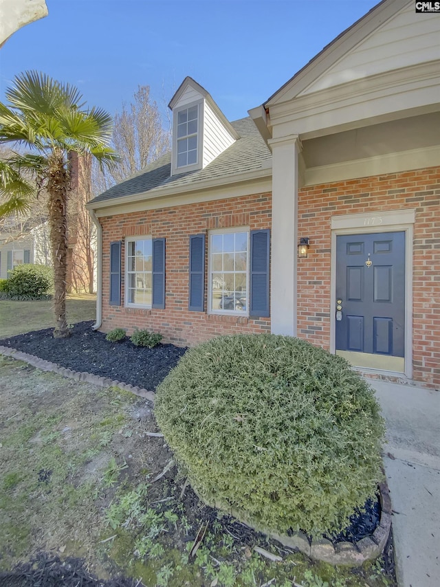 view of exterior entry with brick siding