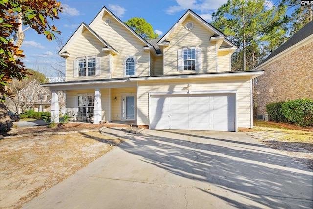 traditional-style house with a porch, an attached garage, and driveway