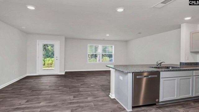 kitchen with baseboards, visible vents, stone countertops, a sink, and dishwasher