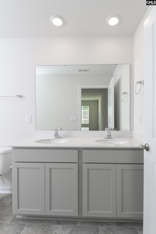 bathroom featuring double vanity, visible vents, and a sink