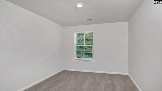 carpeted empty room with visible vents and baseboards