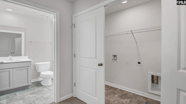 laundry room featuring visible vents, baseboards, hookup for a washing machine, electric dryer hookup, and a sink