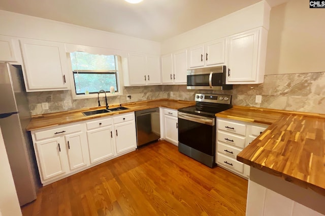 kitchen featuring a sink, dark wood finished floors, stainless steel appliances, and butcher block counters