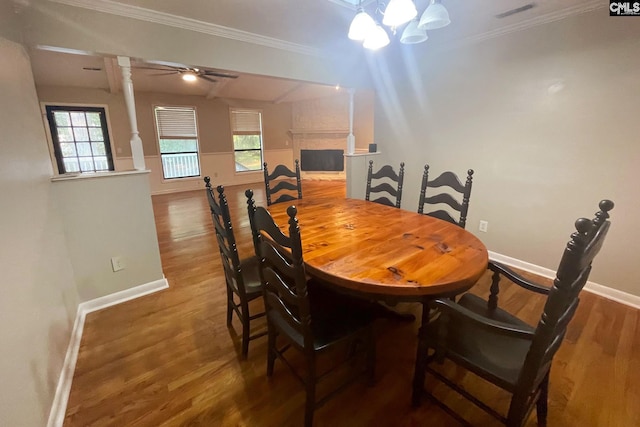 dining area with visible vents, wood finished floors, a fireplace, and ornamental molding