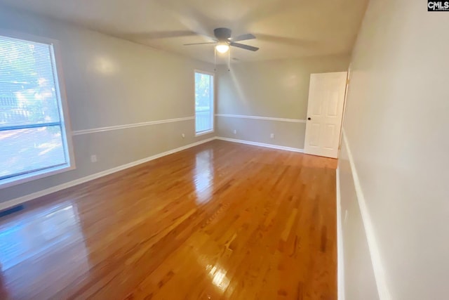 empty room with light wood finished floors, ceiling fan, and baseboards