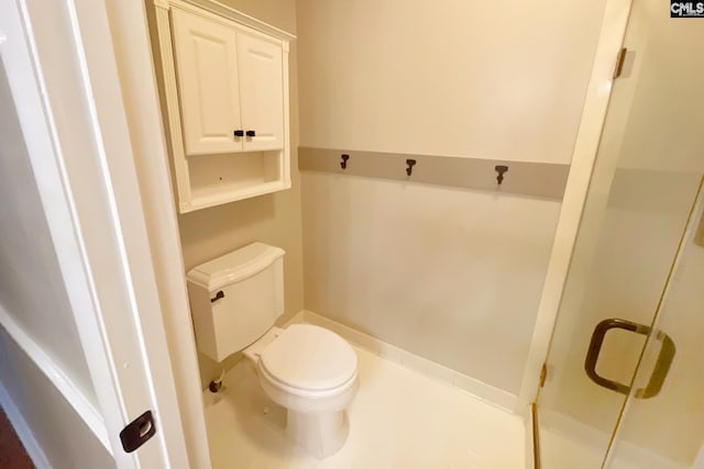 bathroom with a shower stall and toilet