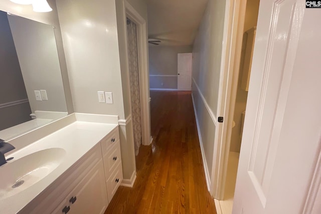 bathroom with baseboards, wood finished floors, and vanity