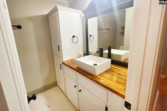 bathroom featuring vanity, baseboards, and marble finish floor