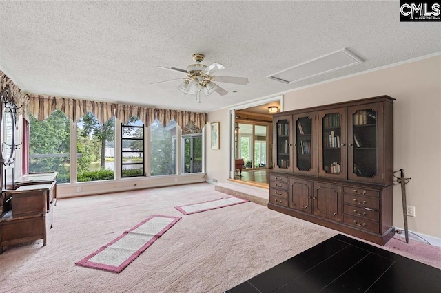 interior space with plenty of natural light, crown molding, a ceiling fan, and carpet floors