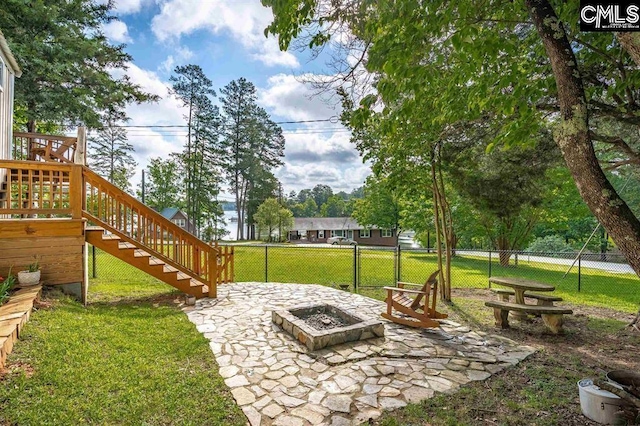 view of yard featuring a deck, fence, an outdoor fire pit, stairs, and a patio area