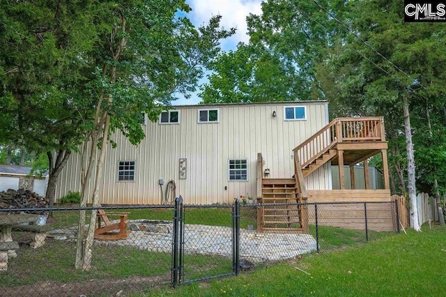 rear view of property with fence, a deck, stairs, and a gate