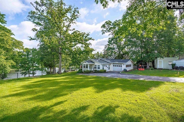 view of front of property featuring a garage, a front yard, and fence