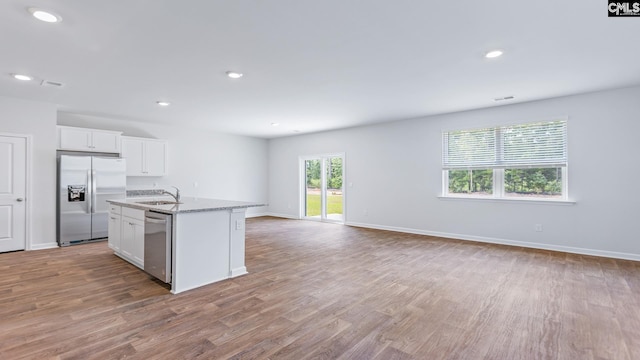 1304 Mosser Dr, Columbia, SC 29203 - kitchen featuring a sink, wood finished floors, open floor plan, white cabinetry, and appliances with stainless steel finishes