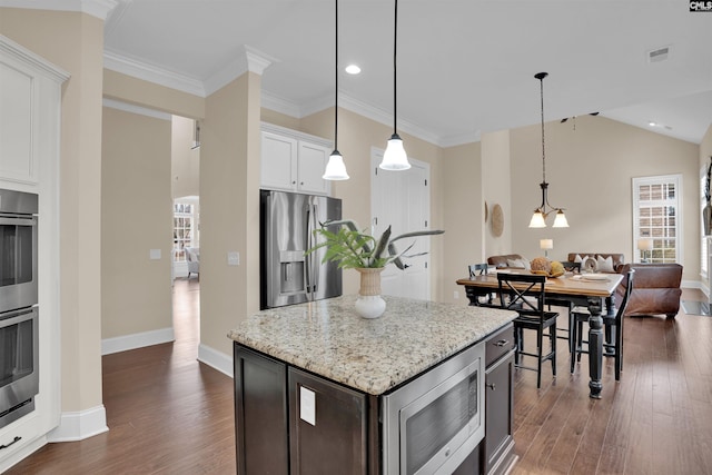 kitchen featuring light stone counters, visible vents, stainless steel appliances, and dark wood-style flooring