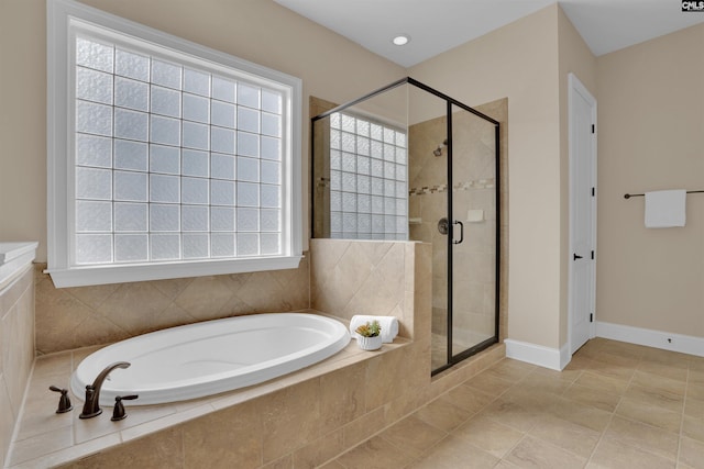 bathroom featuring a bath, a stall shower, and a wealth of natural light