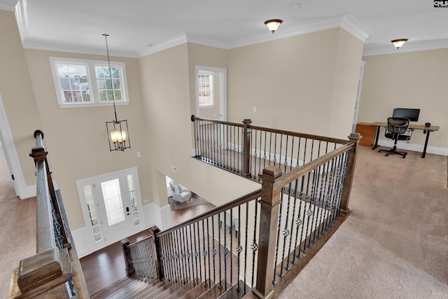 stairway featuring baseboards, carpet floors, an inviting chandelier, and ornamental molding