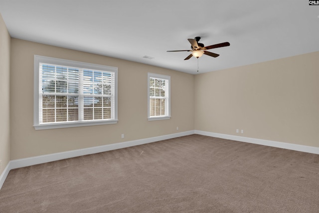 unfurnished room featuring visible vents, carpet, baseboards, and ceiling fan